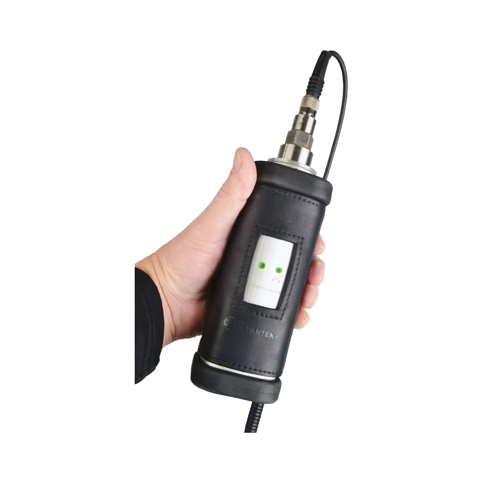 Hand holding a black Svantek SV 110 Vibration Calibrator with a white background